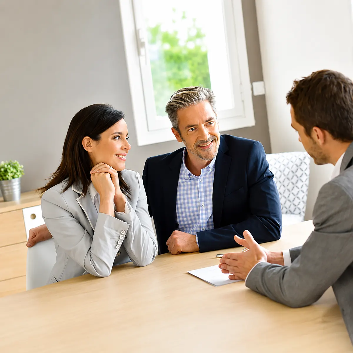 Couple souriant en rendez-vous avec un conseiller NEOXA FINANCE pour un prêt professionnel